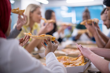 multiethnic business team eating pizza