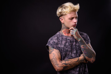 Young handsome rebellious man with blond hair and tattoos