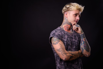 Young handsome rebellious man with blond hair and tattoos