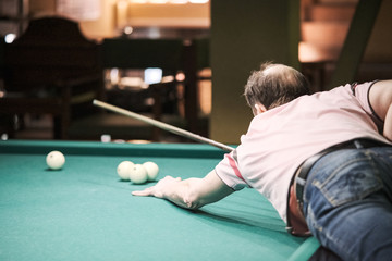 the player takes aim at the ball in Billiards