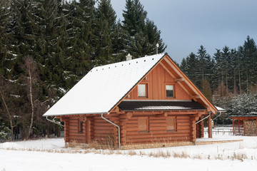 Wooden cottage in forest in winter -  accommodation for winter holiday