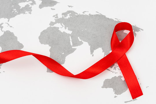 Aids Awareness Red heart Ribbon on world map .