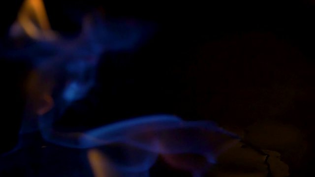 SLOW-MO, NEON BLUE FIRE BOUNCING around edges of the flammable substance before igniting into full flame.