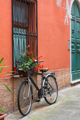 Fototapeta na wymiar Old bike standing in a typical italian narrow street, Portovenere, Italy