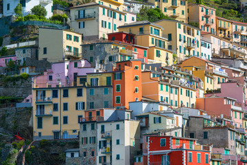 Fototapeta na wymiar View on seaside and typical colorful houses in small village, Riomaggiore, Cinque Terre, Italy