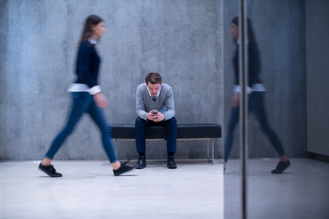 businessman using mobile phone while sitting on the bench