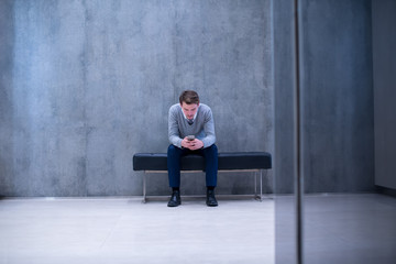 businessman using smart phone while sitting on the bench