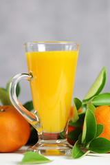 Glass of orange juice with oranges fruit on wooden table. Summer drink.