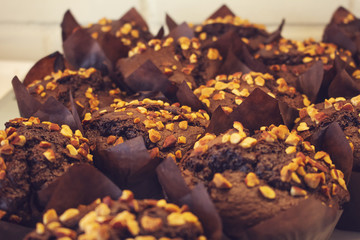 Several chocolate muffins with nut toppings