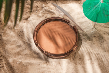  Bronzer in the form of a cushion on the sand, with an umbrella and a palm branch. the shadows of...