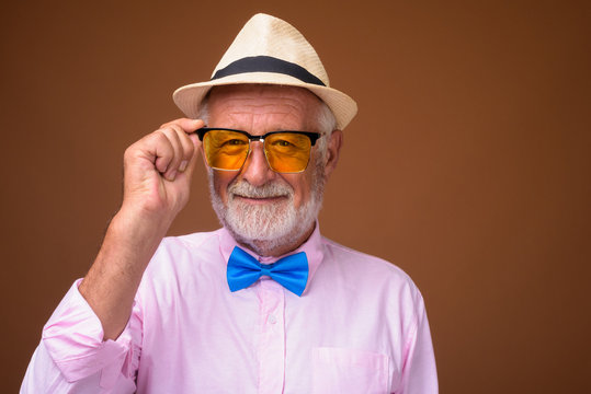 Senior handsome tourist man wearing stylish clothes against brow