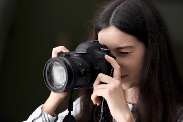 Young girl with modern photo camera at home