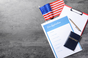 Visa application form, passport and USA flag on table. Concept of immigration