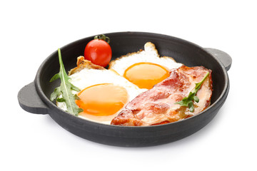 Frying pan with eggs and bacon on white background