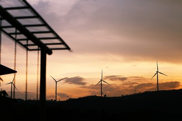 Obraz premium Silhouette of wind turbines at sunset