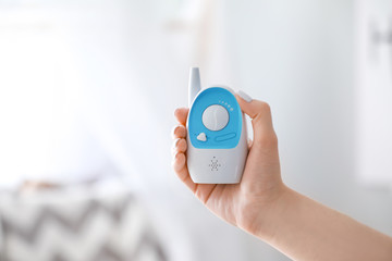 Woman with modern baby monitor at home