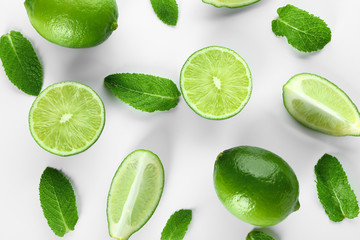 Fresh limes and mint leaves on white background