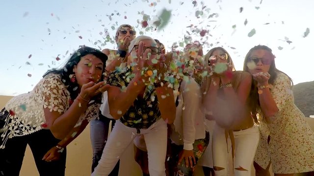 Group of people celebrate together with confetti - romantic sparklers for party event like birthday or carnival - together in friendship concept lifestyle for girls and seniors - celebration 
