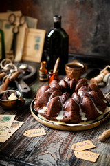 Delicious homemade chocolate bundt cake on wooden plate stands on rustic table