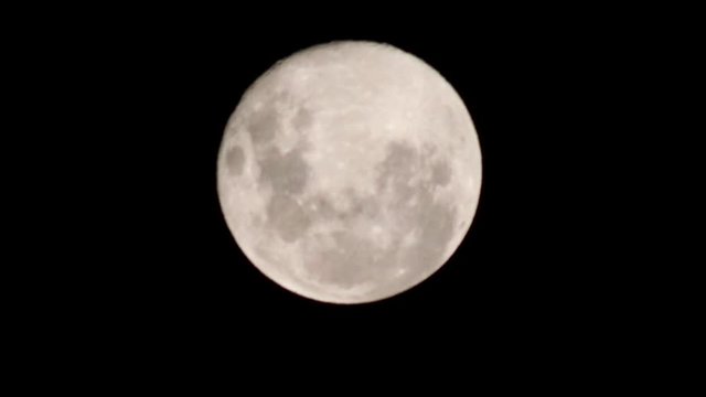 Close up of a full moon in a dark black night's sky.