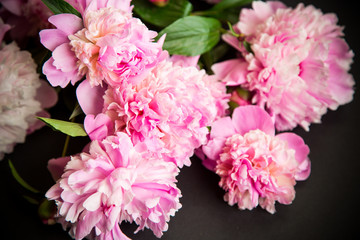 bouquet of blooming peonies on black background