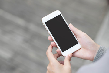close up hand young woman in watching message on mobile smart phone during break. using cell phones to communicate in the online world. with blank or empty black screen 