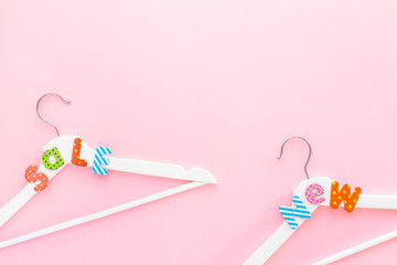 White hangers with sale text on pink background