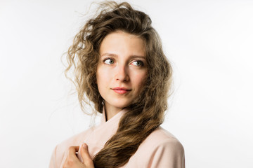 pretty girl with long curly hair in a pink jacket on a white background