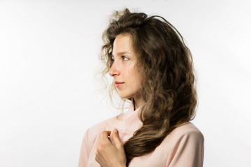 Fototapeta premium pretty girl with long curly hair in a pink jacket on a white background