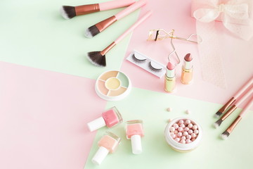 Makeup products, decorative cosmetics on pastel color pink mint background  flat lay.  Fashion and beauty concept. Top view. Copy space.
