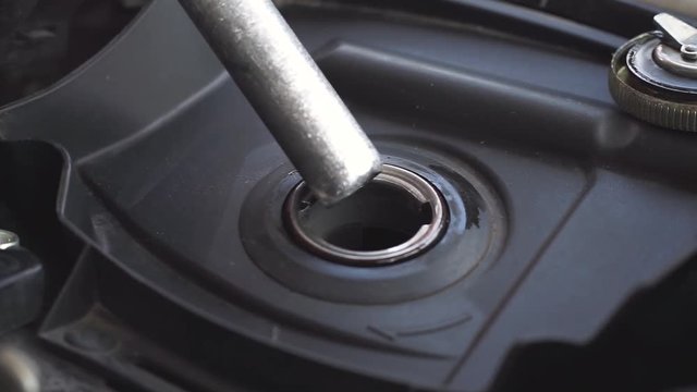 Closeup of fuel nozzle ejects benzine to motorcycle or scooter fuel chamber