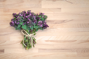Fototapeta na wymiar Bouquet of violet flowers on a wooden background