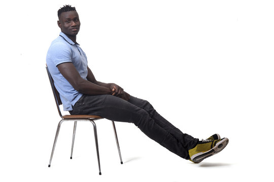 full portrait of african man sitting a chair on white background