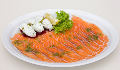 Red fish sliced on white plate, restaurant table setting, cheese paste, lemon, white background