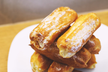 eclairs cakes lie on a white plate.  sweet cakes eclairs