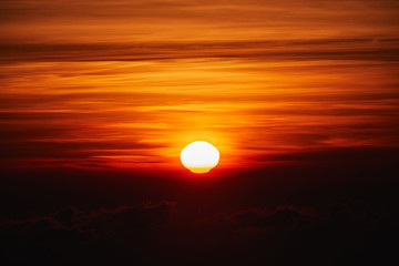 Sunrise / sunset over the clouds and horizon in golden colors.