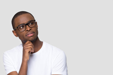 Pensive thoughtful young guy pose on grey wall looking aside