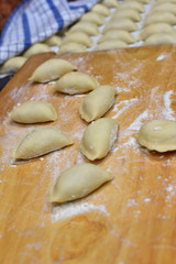 Raw dumpling covered with flour, making cooking pierogi