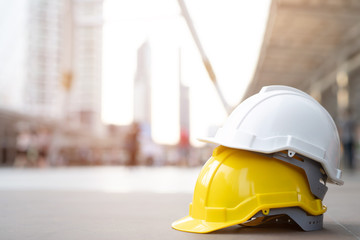 yellow and white hard safety wear helmet hat in the project at construction site building on...