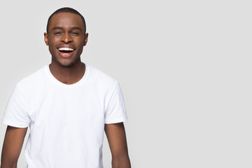 African man laughing looking at camera isolated on grey blank