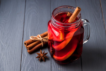 Mulled wine and spices on gray wooden background. Selective focus.