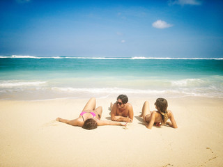 Friends enjoying on a sandy tropical ocean / sea beach.