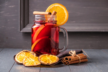 Mulled wine and spices on gray wooden background. Selective focus.