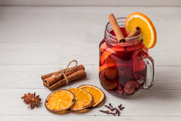 Mulled wine and spices on white wooden background. Selective focus.