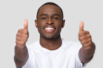 African man feels happy showing thumbs up looking at camera