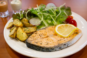 Roasted salmon steak with salad and fries potato, Healthy menu from fish with fresh vegetables.