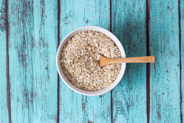 top view of cereals in white bowl on blue background
