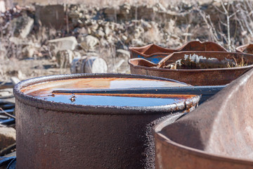 Group of old, rusty barrels with toxic chemical  waste.