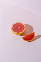 Ripe Grapefruit sliced on pink background, concept
