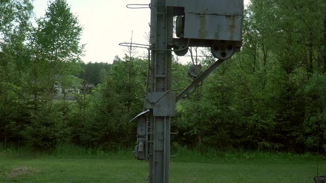 Old Pole holding voltage electric power lines in the middle of the wood. Abandoned pole with electricity which are a prerequisite for driving train.